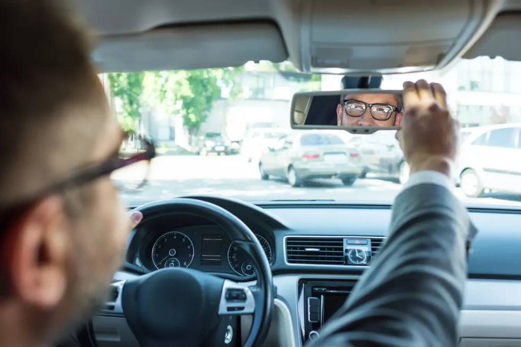 a driver checking a passenger in the rear-view mirror